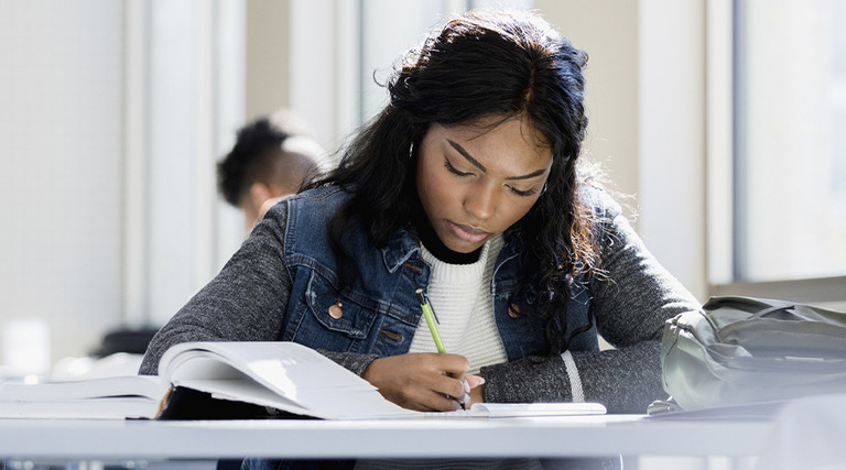 College student reading and working outside of the classroom