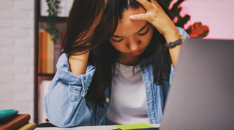Student with head in hands at computer - content filtering