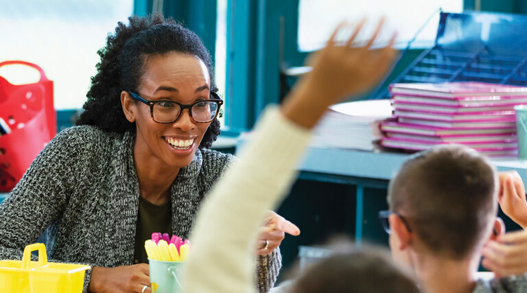 K12 teacher interacting with students in classroom